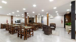 a dining room with wooden tables and chairs at Hotel Gigante Beach Itapema in Itapema