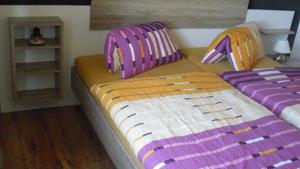 ジンメラートにあるFerienwohnung Schroiffのベッドルーム(紫のクッションが付いたベッド2台付)