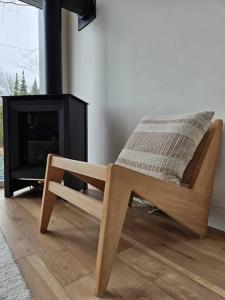 a wooden chair sitting in front of a fireplace at Chalet Le Hygge Hytte - Ski - Golf - Spa in Thetford Mines +52 photos