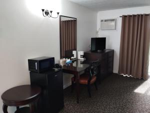 a room with a desk with a computer and a chair at Tri Terrace Motel in West Branch