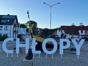 a sign that reads happy poop in a town at Apartamenty BLAST nad morzem Chłopy in Chłopy