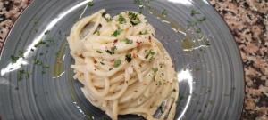 a plate of pasta with sauce and chives on it at locanda genovese 20 in La Maddalena