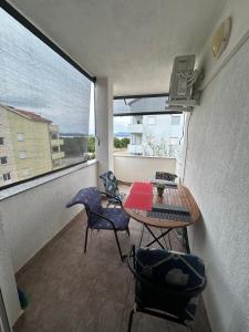 a balcony with a table and chairs and a window at Apartments Marina in Posedarje +5 photos