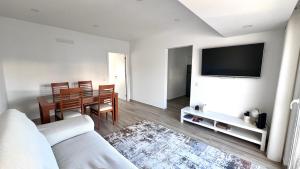 a living room with a couch and a table with a television at The Cate House - Casa renovada a 3 minutos do Centro Histórico in Lagos