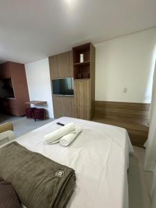a bedroom with a white bed with a television on it at Villas do Porto APTO 05 - Porto de Galinha in Porto De Galinhas +16 photos