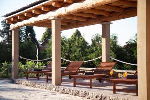 a group of chairs sitting under a wooden pergola at Lika Story in Josipdol