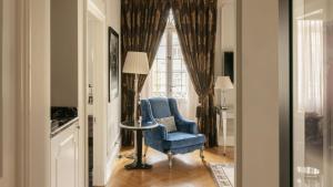 a living room with a blue chair and a window at InterContinental Porto - Palacio das Cardosas by IHG in Porto