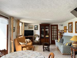 a living room with a couch and a tv at La Charmante in Le Vigan