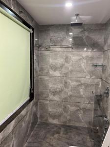 a bathroom with a shower with a stone wall at ARANYAM By StarGlaze Retreat in Mahabaleshwar