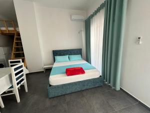 a bedroom with a bed with a red pillow on it at Liza's apartment 1f in Skataj