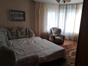 キシナウにあるМиорицаのベッドと椅子と窓のある寝室