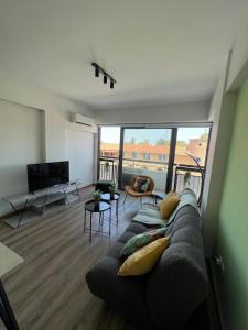 Una sala de estar con un sofá y un televisor de pantalla plana. en Azul sea view, en Lárnaca