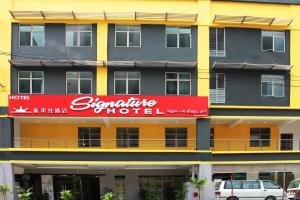 un gran edificio amarillo con un letrero rojo. en Signature Hotel @ Bangsar South, en Kuala Lumpur
