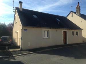 a small white house with a black roof at Les Renaudines in Château-Renault