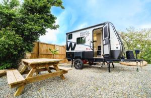 a trailer with a picnic table and a bench at Aleli Cottages in Culebra
