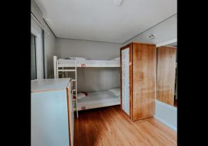 a small room with two bunk beds and a refrigerator at Pup Hostel SC in Florianópolis