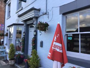 a red umbrella sitting outside of a building at Dolphin Inn in Llanymynech