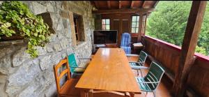 a wooden table and chairs on a porch at Finca la Vegacha casa tradicional pasiega in San Roque de Ríomiera