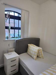 a bed with a pillow next to a window at Home away from Home in Burton upon Trent