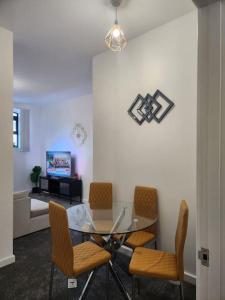 a dining room with a glass table and chairs at Home away from Home in Burton upon Trent