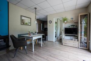 a living room with a table and a television at Jamies Cottage Warmenhuizen nu met airco in Warmenhuizen