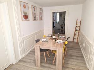 a dining room with a wooden table and chairs at La Bohème - Idéal familles, hyper centre in Mulhouse +69 photos