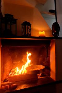 a fire in an oven with a pan in it at La Volpe e la Rosa in Uscio +12 photos