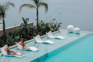 a group of people sitting in chairs in a swimming pool at Radream Hotels & Spa in Vlorë