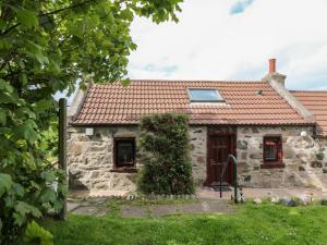 una casa in pietra con tetto rosso di Viola Cottage a Fraserburgh