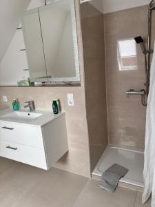 a bathroom with a sink and a tub and a mirror at Zimmer mit Küche und Bad in Wedemark +4 photos