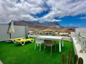 a patio with a table and chairs on a roof at Agaete Sunset in Agaete