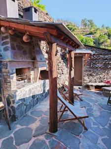 an outdoor pizza oven sitting on a stone patio at Casa dos avós 23 in Castro Daire
