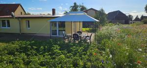 a gazebo with a table and chairs in a garden at Landleben! Bungalow Feldblick 5 Personen in Blankensee