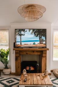 a living room with a fireplace with a television above it at Hedgehog Lodge at Owlet Hideaway - with Hot Tub, near York in Seaton Ross