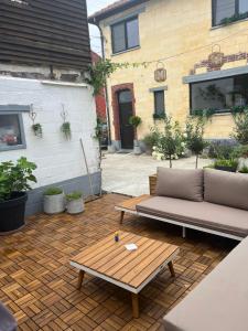 a patio with a couch and a coffee table at De Koer Kanne - bij Maastricht in Kanne
