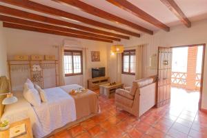 a bedroom with a bed and a chair at Villa Castillo in Frigiliana