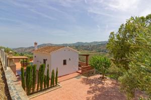 a small white house with a fence and trees at Villa Castillo in Frigiliana