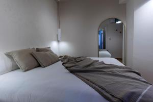 a bedroom with a large white bed with a mirror at Hygge al Conero - Marcelli in Marcelli