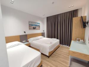 クサミルにあるHotel PAJA Ksamilのベッド2台とテレビがあるホテルの部屋 +16枚の写真