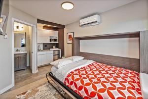 a bedroom with a large bed and a kitchen at Walkable Wonder Midtown Studio near Downtown Gems in Reno