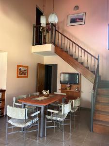 a dining room with a table and chairs and a staircase at El Recuerdo in Merlo +3 photos