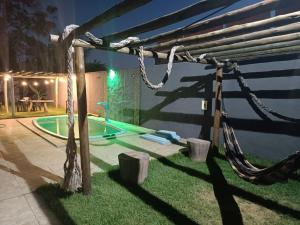 un cortile con una recinzione di corda e una piscina di Flats e Suites Toque dos Milagres a São Miguel dos Milagres