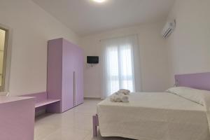 a bedroom with a bed with purple and white at B&B La Dea in Marzamemi