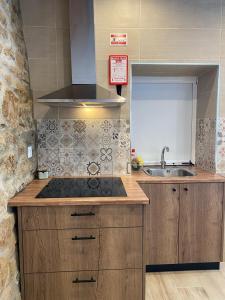 uma cozinha com um fogão e um lavatório em Cantinho D'Avó Maria em Zebreira