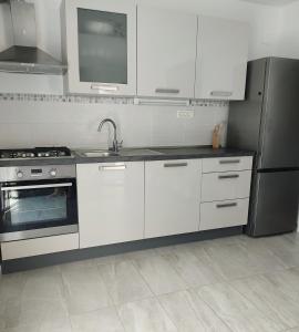a kitchen with white cabinets and a stainless steel refrigerator at Apartman Mali Tare in Korčula +8 photos