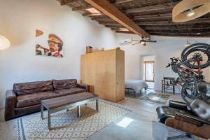 ein Wohnzimmer mit Sofa und Fahrrad an der Wand in der Unterkunft Modern Historic 1900 Adobe Bungalow in Downtown in Tucson