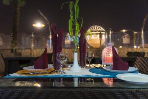 a table with plates and wine glasses on it at Sharz Hotel in Buraydah