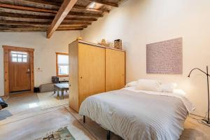 ein Schlafzimmer mit einem großen Bett und einem Holzschrank in der Unterkunft Modern Historic 1900 Adobe Bungalow in Downtown in Tucson