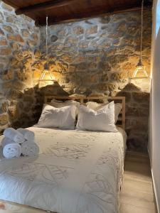 um quarto com uma cama numa parede de pedra em Cantinho D'Avó Maria em Zebreira