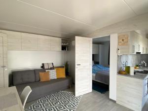 a living room with a couch and a bed at Mediterranean mobile homes - Lotty in Drage